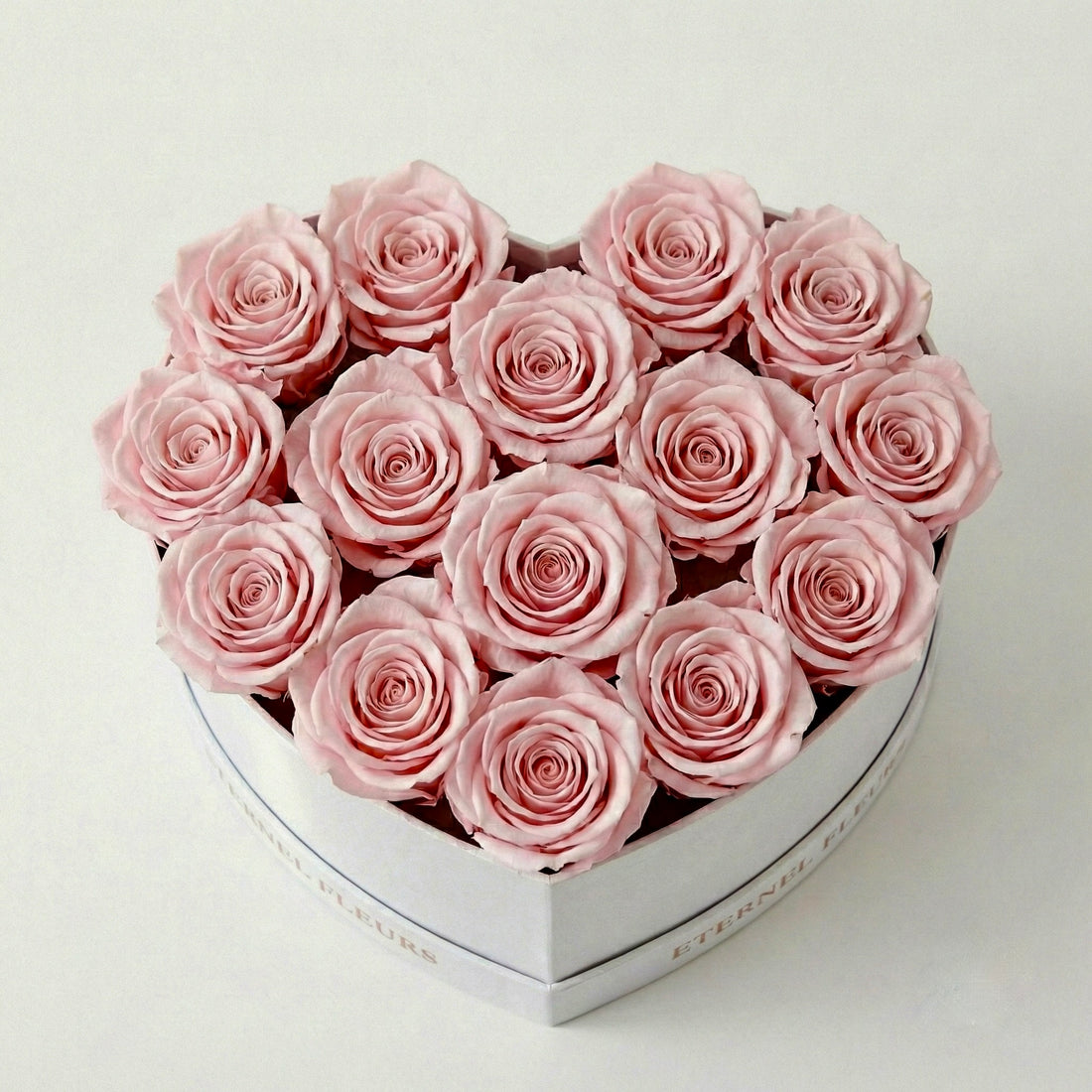 White round box with pink roses on a light gray background