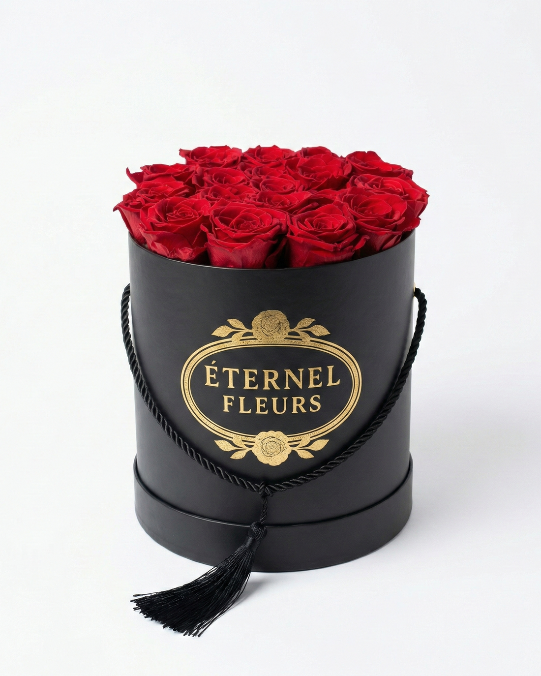 Black cylindrical box with red roses and 'Éternel Fleurs' branding on a white background