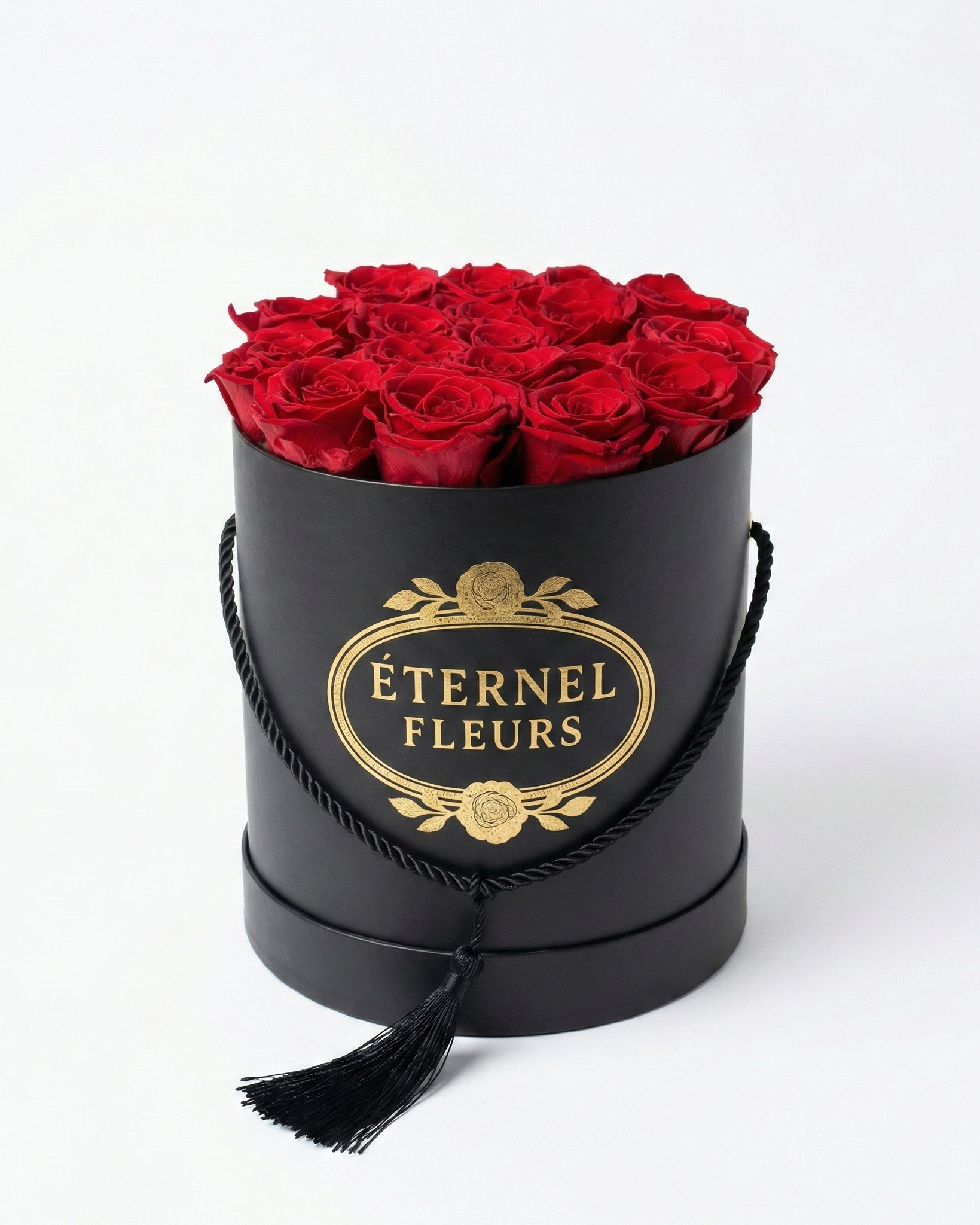 Black cylindrical box with red roses and 'Éternel Fleurs' branding on a white background